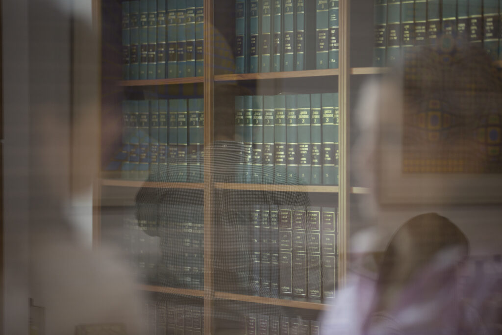 reflection of lawyers with a legal library in the background